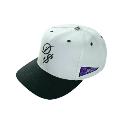 DS Hat: Classic 6-panel snapback design with premium embellishments including an embroidered D$ logo, gun-metal top buttons, and a rich purple hue under the brim. 