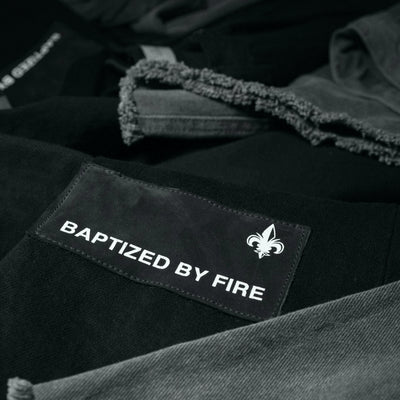 Denim Flare: Premium distressed aesthetics featuring our bold “Baptized by Fire” iconography on a flared silhouette. 